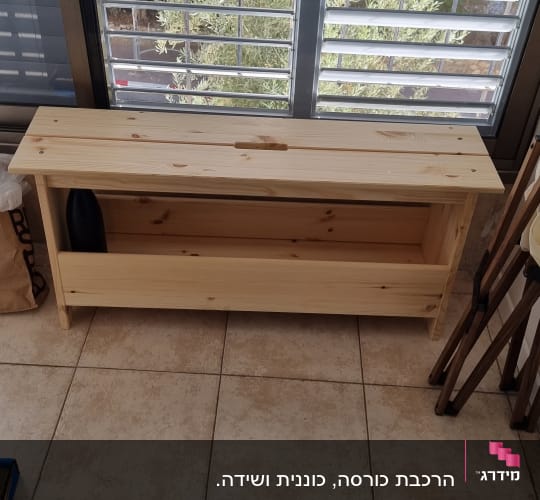 ספסל עץ ליד חלון עם תריסים